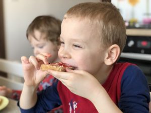 Little boy eating homemade sourdough bread with jam