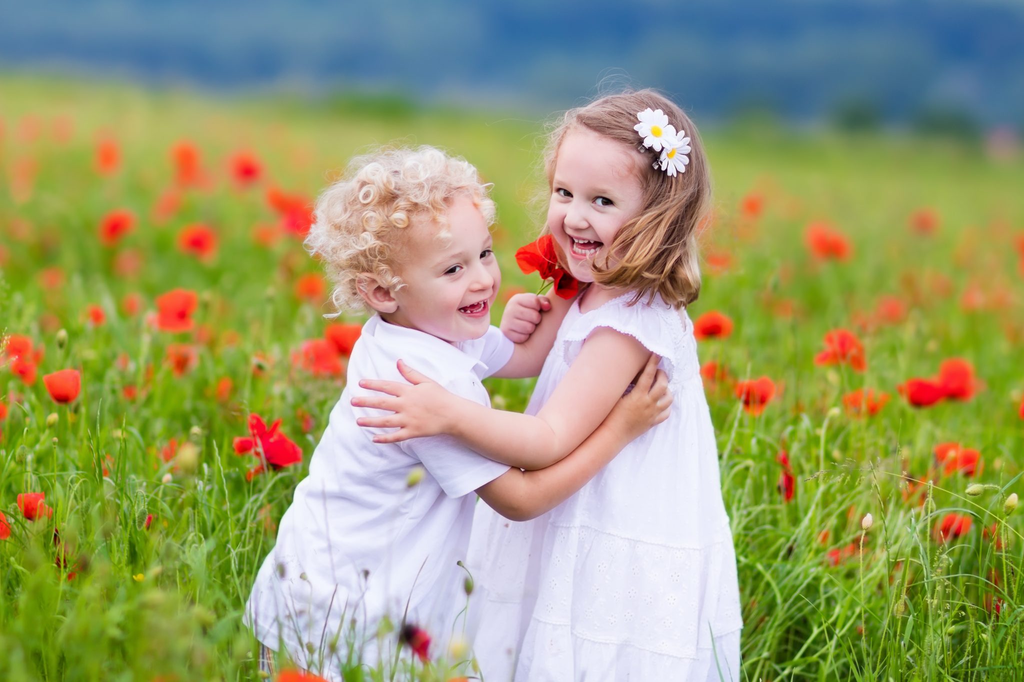 siblings with poppy flowers
